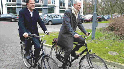  Primeiro-ministro (esquerda) e o líder parlamentar da Holanda,                          chegam à residência oficial de bicicleta. 