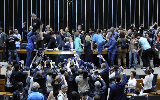 Grupo intervencionista quebrou vidraça e promoveu confronto com a Polícia Legislativa; sessão de discussões foi suspensa e cinegrafistas foram retirados - Momento em que o grupo tomou o entorno da mesa de onde os membros da Mesa Diretora comandam os trabalhos.