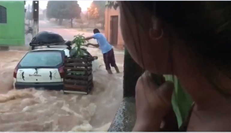 Moradores amarram carro para não ser levado por forte chuva 